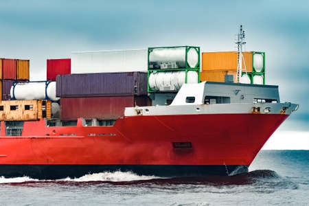 Red cargo container ship's bow in cloudy dayの写真素材
