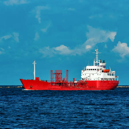 Red cargo tanker ship moving by the riverの写真素材