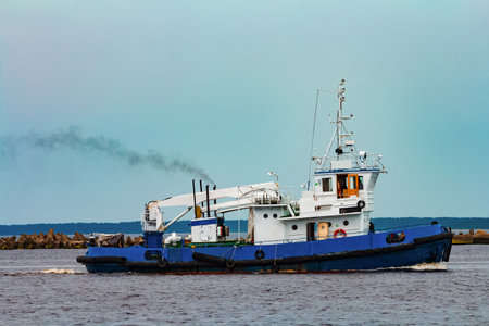 Blue tug ship moving to the cargo terminal. Industrial servicesの写真素材