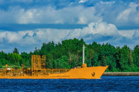 Yellow cargo tanker ship moving at the clear summer day