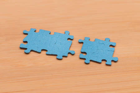 Top View of a Blue Puzzle Peaces Lie on the Wooden Tableの写真素材