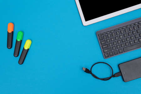 Office Workplace with Digital Gadgets Lying on Blue Table - Flat Layの写真素材