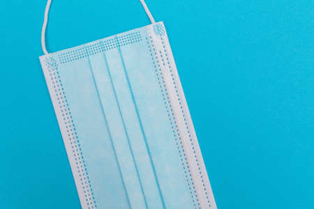 Blue Medical Mask on Blue Background - Top View, Flat Lay