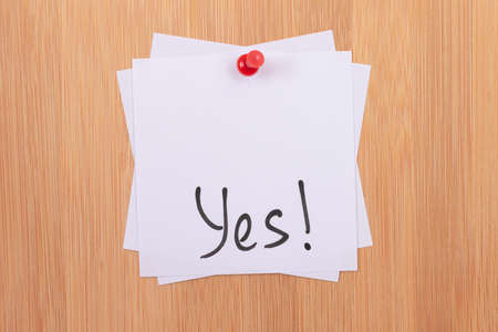 YES! - White Sticky Notes with Written Word YES, Pinned to the Wooden Message Board. To Do List Reminder in the Office. Memo Note at Workの写真素材