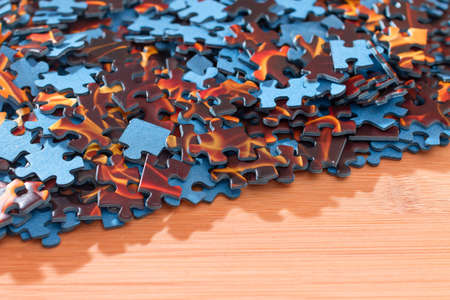Colorful Peaces of a Mixed Jigsaw Puzzle Lie on the Wooden Table - Strategy and Solving Problem...