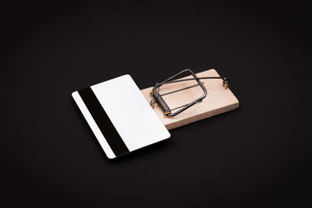 Credit Risk and Loan Trap - White Blank Credit Card Template in Wooden Mouse Trap on Black Backgroundの写真素材