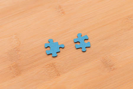 Top View of a Blue Puzzle Peaces Lie on the Wooden Tableの写真素材