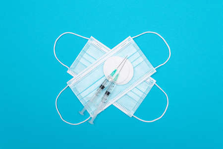Vaccination, Immunology or Revaccination Concept - Two Medical Syringe and the Medical Mask Lying on...
