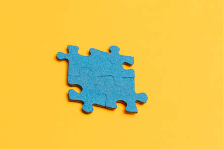 Top View of a Blue Puzzle Peaces Lie on the Yellow Backgroundの写真素材
