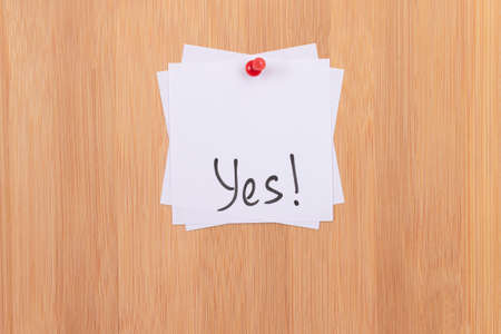 YES - White Sticky Notes with Written Word YES, Pinned to the Wooden Message Board. To Do List Reminder in the Office. Memo Note at Workの写真素材