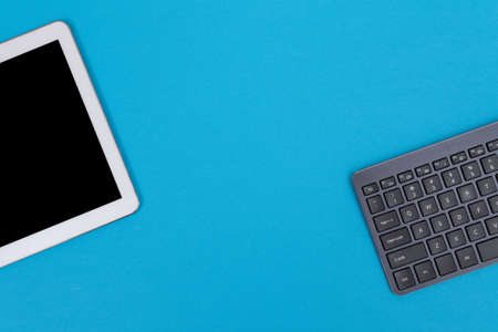 Office Workplace with Digital Gadgets Lying on Blue Table - Flat Layの写真素材