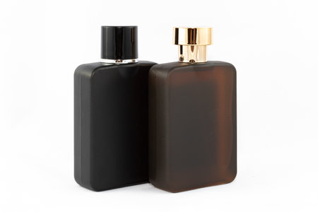 Two Matte Bottles of Perfume for Men on White Background - Close-Up. Black and Brown Blank Glass Spray Bottles with Men Perfume - Mock Upの写真素材