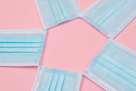 Medical Equipment. Five Disposable Medical Face Masks Lying on Pink Backgroundの写真素材