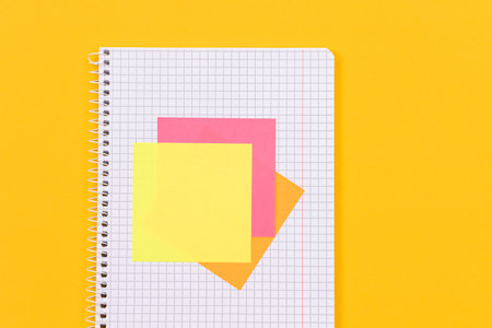 A Notepad with Sticky Notes Lying on Yellow Table - Blank Template. Top View, Flat Layの写真素材
