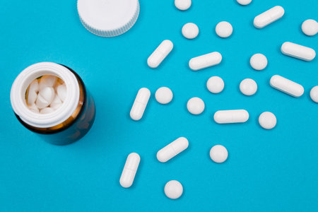 Global Pharmaceutical Industry and Medicinal Products - White Pills or Tablets Scattered from the...