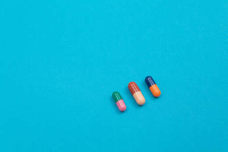 Global Pharmaceutical Industry and Medicinal Products - Colored Pills or Capsules Scattered on Blue Backgroundの写真素材