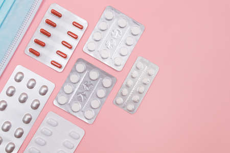 Different Pills and Tablets Package on Pink Background. Top View, Flat Layの写真素材