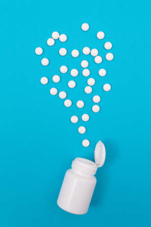 Global Pharmaceutical Industry and Medicinal Products - White Pills or Tablets Scattered from the Bottle, Lying on Blue Background, Top View, Flat Layの写真素材