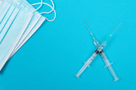 Vaccination, Immunology or Revaccination Concept - Two Medical Syringe Lying on Blue Table in Doctors Office in a Hospital or Clinicの写真素材