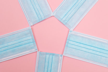 Medical Equipment. Five Disposable Medical Face Masks Lying on Pink Backgroundの写真素材