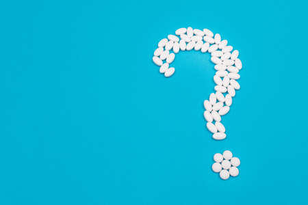 Question Mark Made from White Pills and Tablets, Lying on Blue Background. Global Pharmaceutical Industry and Medicinal Productsの写真素材