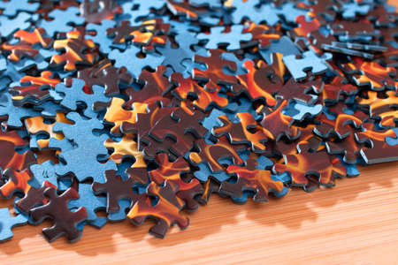 Colorful Peaces of a Mixed Jigsaw Puzzle Lie on the Wooden Table - Strategy and Solving Problem Conceptの写真素材