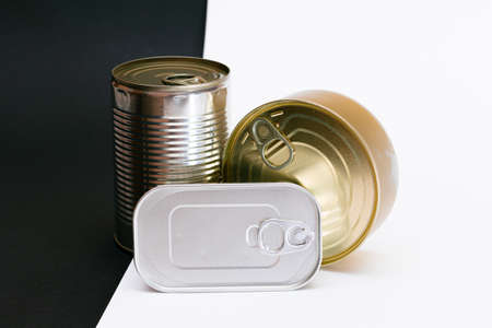 A Group of Stacked Tin Cans with Blank Edges on Split Black and White Background. Canned Food....
