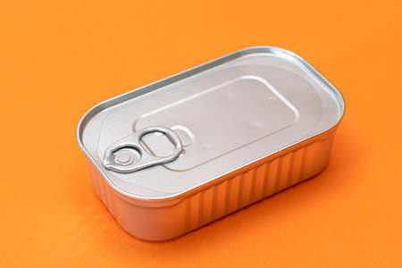 Unopened Tin Can with Blank Edge on Orange Background. Canned Food. Aluminum Can for Safe and Long...