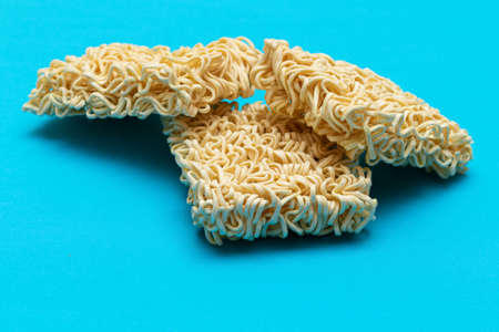 Uncooked Instant Noodles on Blue Background. Raw Pasta. Dry Asian Fast Food. Quick Lunchの写真素材
