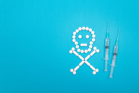 Dangerous Pharmaceutical Products or Unsafe Pills and Tablets - Skull or Death Symbol Made from White Pills Lying on Blue Backgroundの写真素材