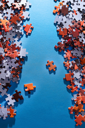 Mixed Peaces of a Colorful Jigsaw Puzzle Lie on the Blue Background - Strategy and Solving Problem Conceptの写真素材