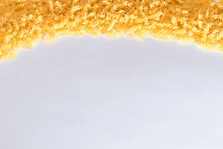 Uncooked Fusilli Pasta with Copy Space on White Background. Raw and Dry Macaroni. Fat and Unhealthy Food - Flat Layの写真素材
