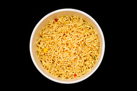 Instant Noodles in Disposable Cup on Black Background - Top View. Asian Fast Food. Quick Lunchの写真素材