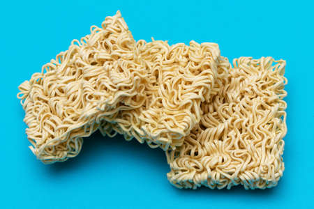 Uncooked Instant Noodles on Blue Background. Raw Pasta. Dry Asian Fast Food. Quick Lunchの写真素材