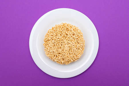 Uncooked Instant Noodles on White Plate. Raw Pasta. Dry Asian Fast Food. Quick Lunch