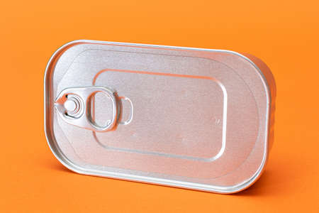 Unopened Tin Can with Blank Edge on Orange Background. Canned Food. Aluminum Can for Safe and Long...