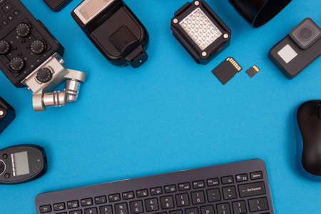 Top View of Photographers, Videographers or Video Bloggers Workplace. Digital Gadgets Lying on Blue Table - Flat Layの写真素材