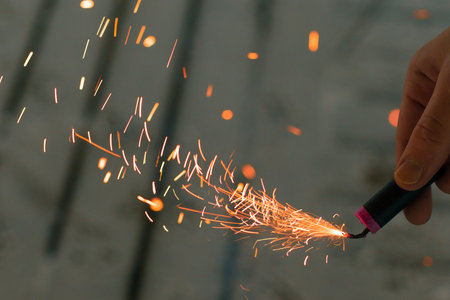 Burning Firecracker with Sparks. Guy Holding a Petard in a Hand. Loud and Dangerous New Years...