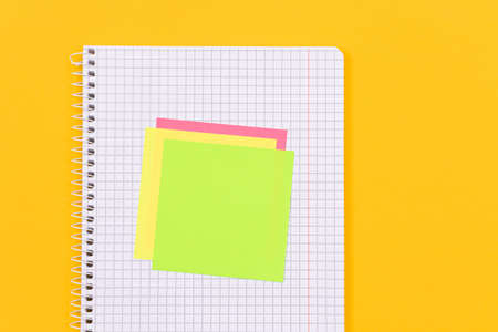 A Notepad with Sticky Notes Lying on Yellow Table - Blank Template. Top View, Flat Layの写真素材