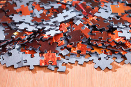Colorful Peaces of a Mixed Jigsaw Puzzle Lie on the Wooden Table - Strategy and Solving Problem Conceptの写真素材