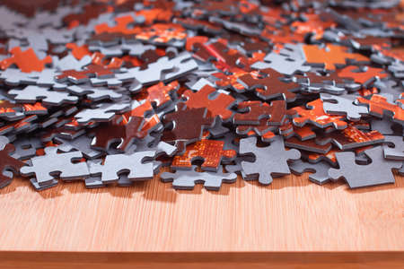 Colorful Peaces of a Mixed Jigsaw Puzzle Lie on the Wooden Table - Strategy and Solving Problem Conceptの写真素材