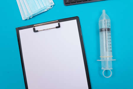 Safe Vaccine, Anti Vaccination Concept - Syringe in a Condom Lay on Blue Table in Clinic or Hospital. Mistrust of Vaccination. Natural Immunity. Skepticism About the Vaccine. Freedom and Human Rightsの写真素材