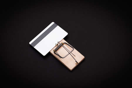 Credit Risk and Loan Trap - White Blank Credit Card Template in Wooden Mouse Trap on Black Backgroundの写真素材