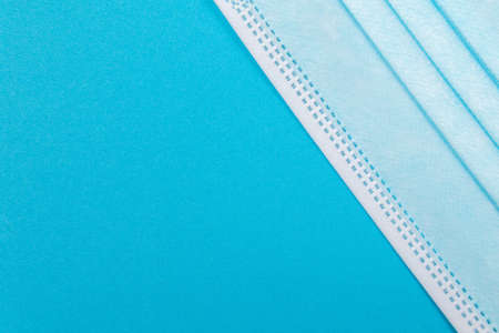 Blue Medical Mask on Blue Background - Top View, Flat Layの写真素材