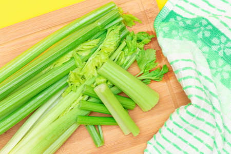 Fresh Celery Stem and Chopped Celery Sticks on Wooden Cutting Board. Vegan and Vegetarian Culture. Raw Food. Healthy Diet with Negative Calorie Content. Slimming Foodの写真素材
