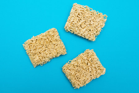 Uncooked Instant Noodles on Blue Background. Raw Pasta. Dry Asian Fast Food. Quick Lunchの写真素材