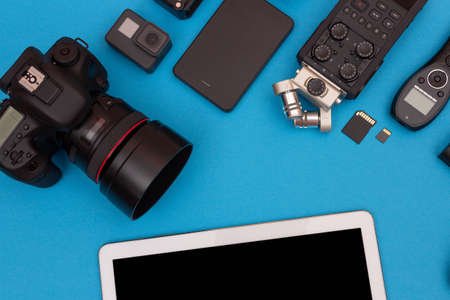 Top View of Photographers, Videographers or Video Bloggers Workplace. Digital Gadgets Lying on Blue Table - Flat Layの写真素材
