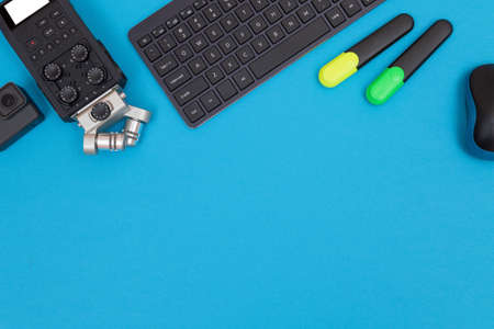Top View of Photographers, Videographers or Video Bloggers Workplace. Digital Gadgets Lying on Blue...