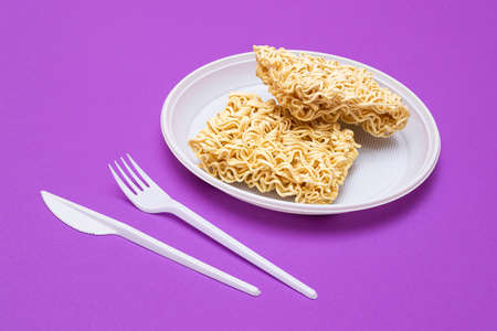 Uncooked Instant Noodles on White Plate. Raw Pasta. Dry Asian Fast Food. Quick Lunchの写真素材