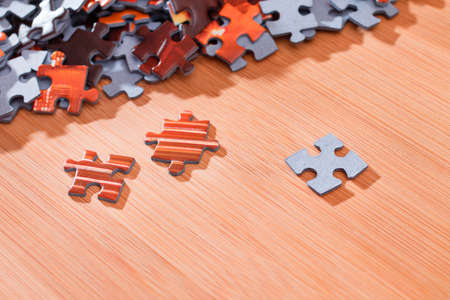 Colorful Peaces of a Mixed Jigsaw Puzzle Lie on the Wooden Table - Strategy and Solving Problem Conceptの写真素材